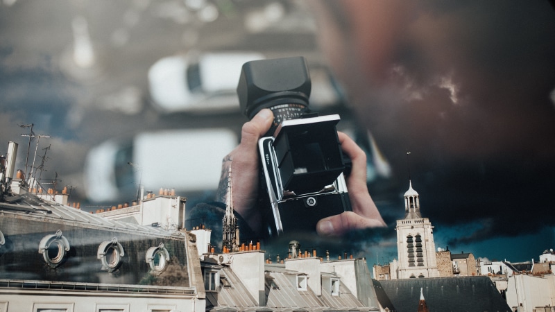 architecture, electronics, text, cityscape, phone, human, wireless technology, men, adult, city, office building exterior, analog film, white, person, camera operator
