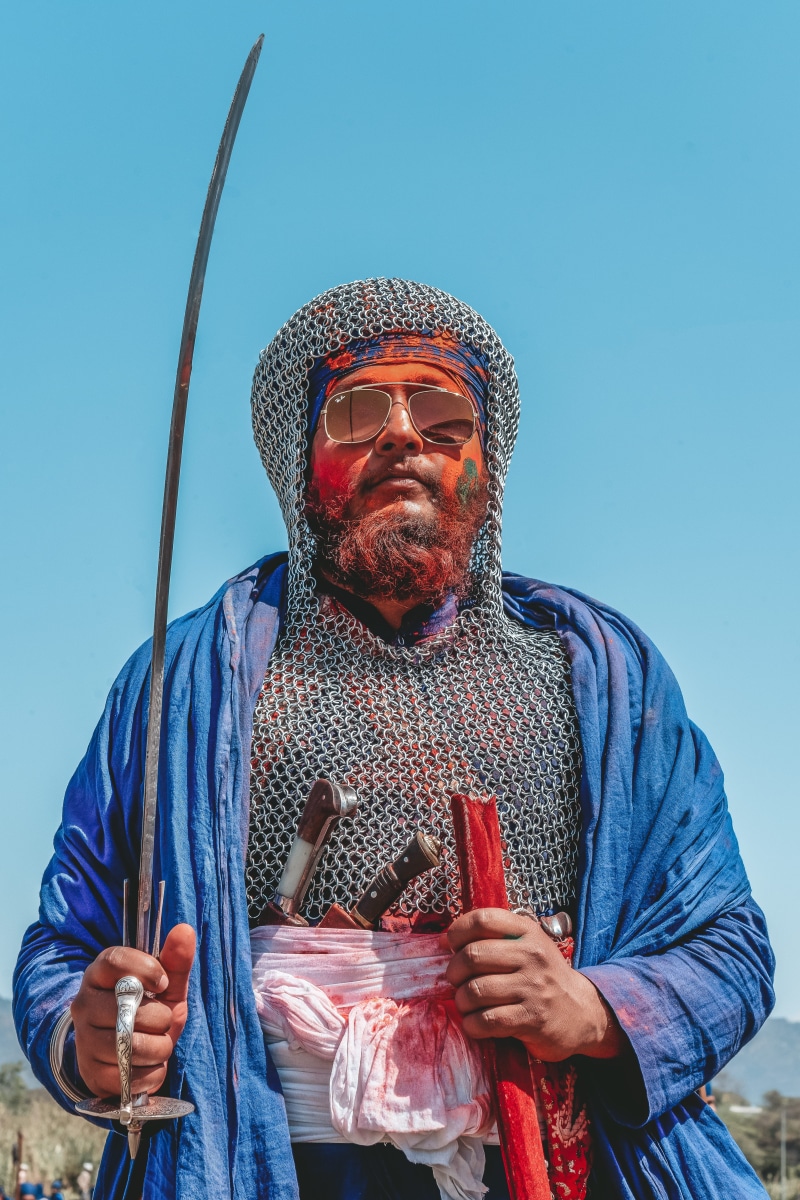 sunglasses, accessories, holding, facial hair, blue, face, color, waist up, sony, standing, holi, hola mohalla, chain mail, front view, anandpur sahib