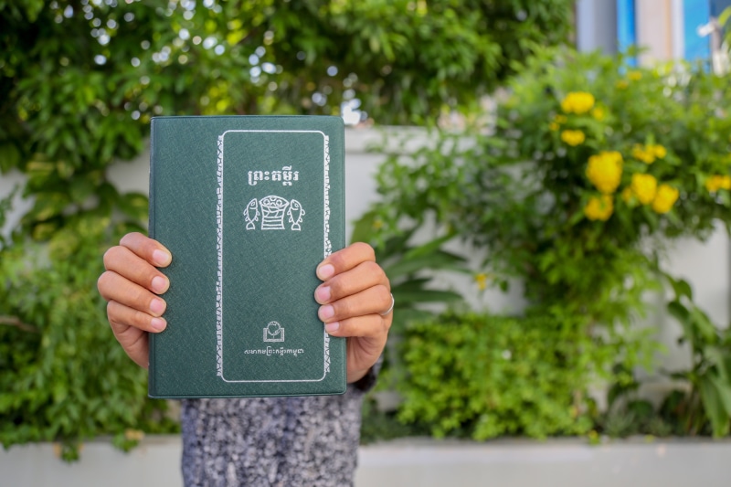learning, tree, day, communication, front view, nature, khmer bible, plant, one person, book, text, growth, cambodia, outdoors, khmer, publication, green
