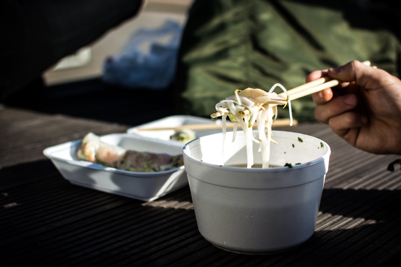 chopsticks, plate, Vietnamese, hands, one person, human body part, one man only, close-up, indoors, focus on foreground, hand, table, people, takeaway