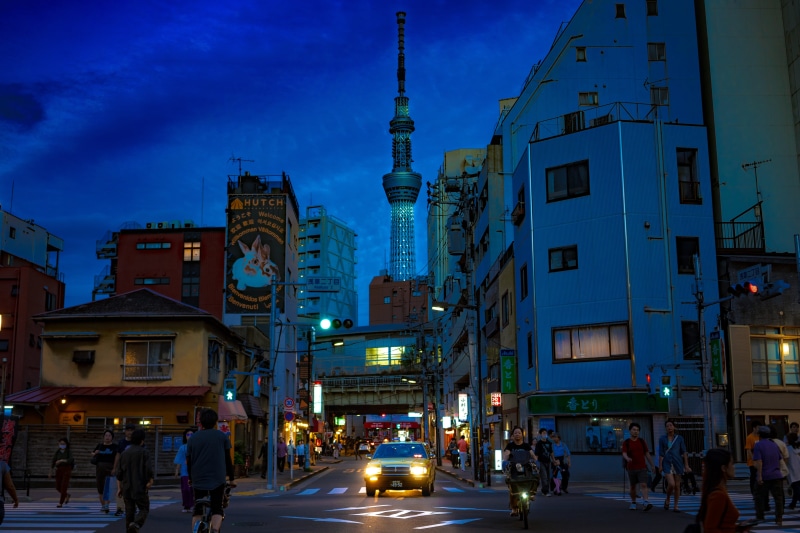 tarmac, vehicle, city, road, car, built structure, tower, skyscraper, outdoors, downtown, person, building exterior, travelling, group of people, nature