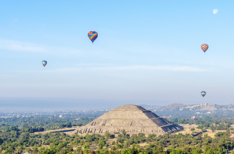 building exterior, parachute, adventure, landscape, 8K, sky, hot, teotihuacan, travel, day, transportation, extreme sports, outdoors, built structure