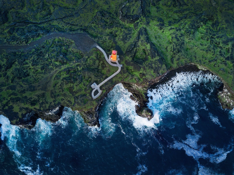 real people, rock, high angle view, green color, non-urban scene, one person, day, coast, tranquility, mountain, Svortuloft Lighthouse, leisure activity