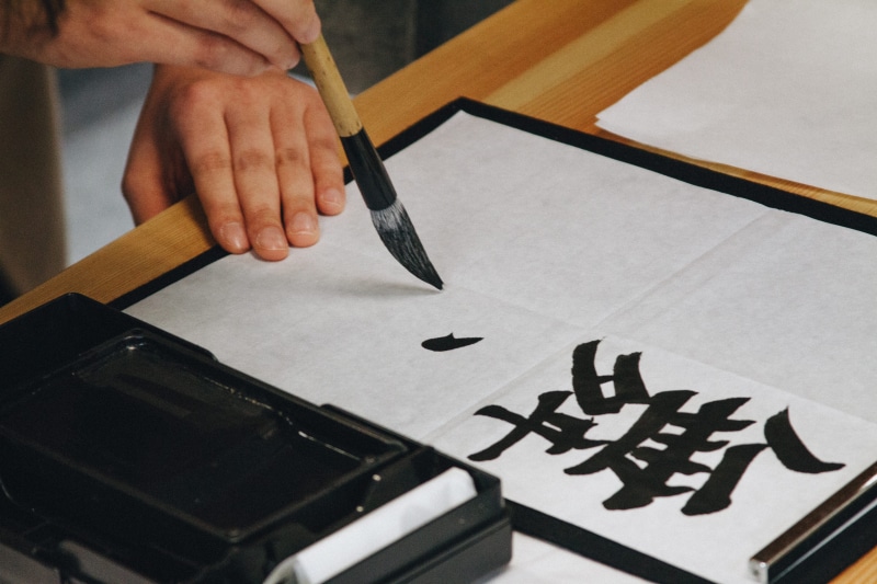 hand, human body part, communication, one person, finger, paintbrush, cretivity, brush, modern, indoors, non-western script, kanji, success, ink, holding
