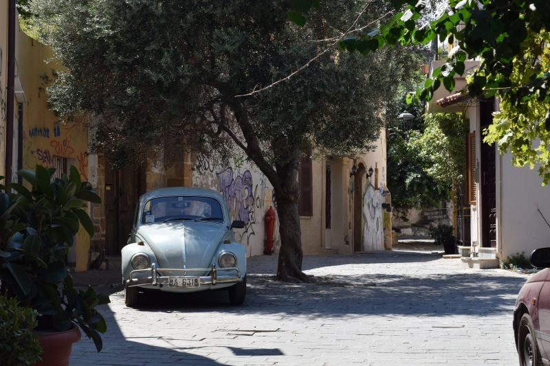 oldtimer, olive tree, built structure, building, city, mode of transportation, sunlight, shadow, day, tree, chania, car, land vehicle, road, beetle, old town