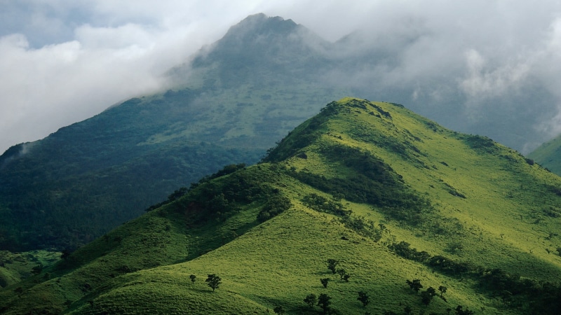 sky, beauty in nature, cloud - sky, scenics - nature, near, hills, tranquility, mountain peak, green color, mountains, environment, day, landscape, tranquil scene