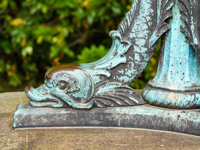 ornate, outdoors, animal representation, brass, focus on foreground, statue, no people, turquoise, day, artwork, sculpture, metal, green, blue, nature