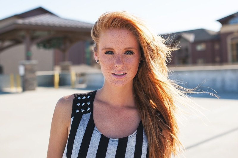 freckles, focus on foreground, outdoors, redhead, swimming pool, beautiful woman, front view, real people, looking at camera, built structure, lifestyles