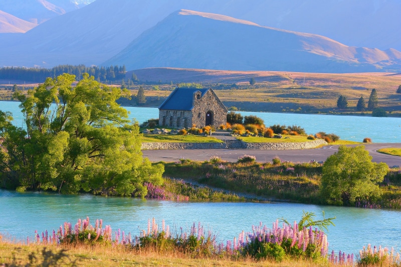 lake, building exterior, nature, landscape, built structure, sky, beauty in nature, house, travel destinations, lake tekapo, morning, architecture, grass