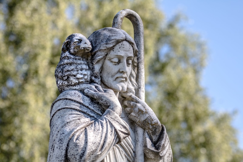 the good shepherd, low angle view, craft, daytime, shepherds staff, creativity, worn, sculpture, cemetery, outdoors, religion, standing, jesus, nature