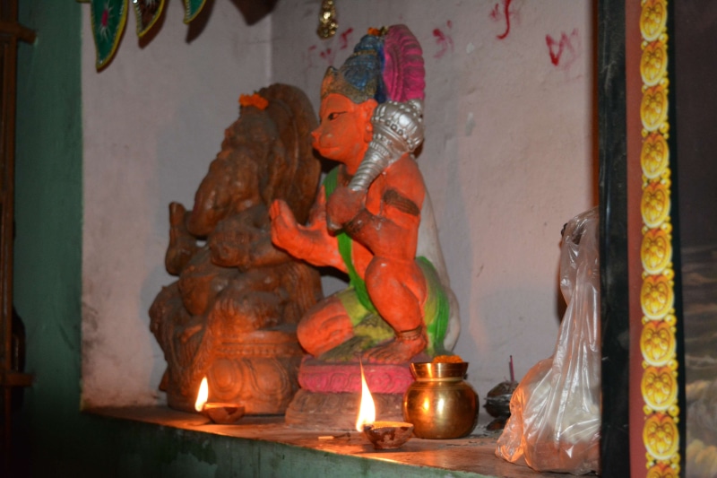 statue, art and craft, shrine, altar, representation, belief, candle, bajrangbali hanuman, male likeness, religion, spirituality, indoors, burning, no people