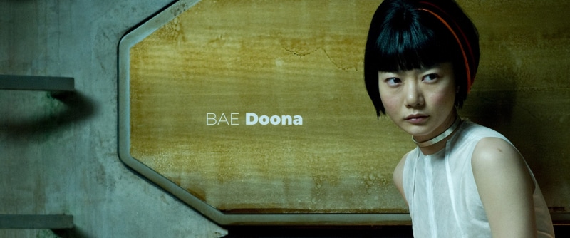 casual clothing, text, Doona Bae, childhood, communication, indoors, Sense 8, one person, standing, child, looking at camera, males, teenager, sign, hairstyle