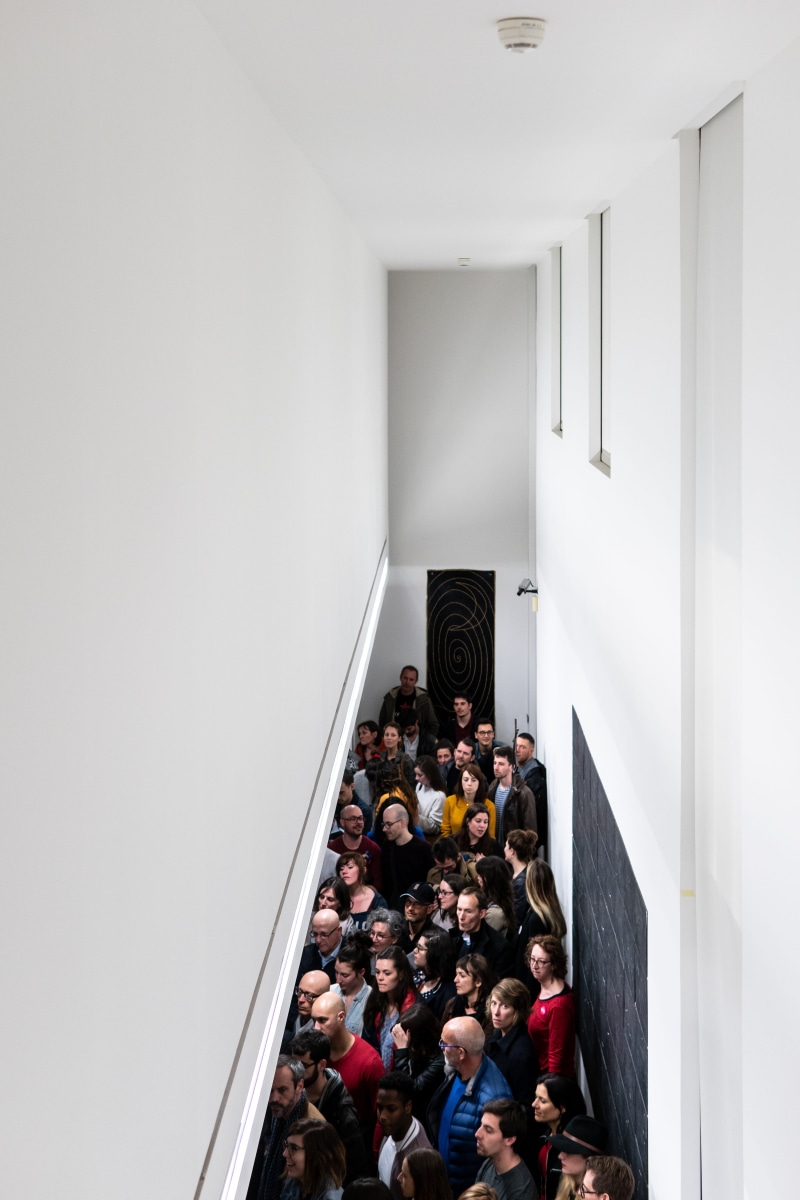 corridor, white, inside, large group of people, exhibition, high angle view, house, ceiling, crowd, built structure, busy, staircase, men, standing, architecture