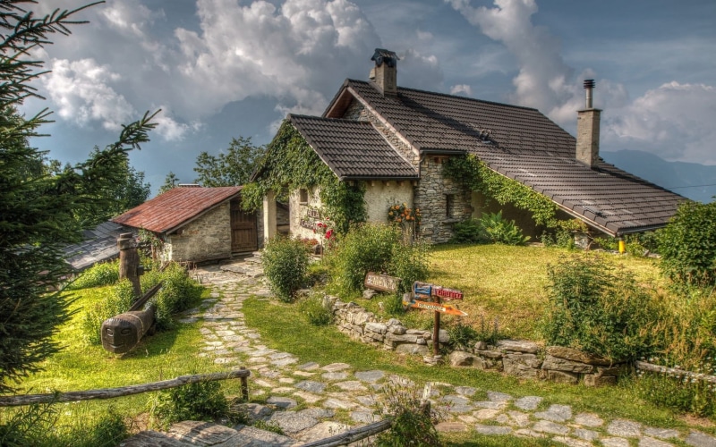 stone house, cloud - sky, land, trees, growth, day, built structure, house, green color, field, plant, sky, tree, no people, clouds, rural scene, residential district