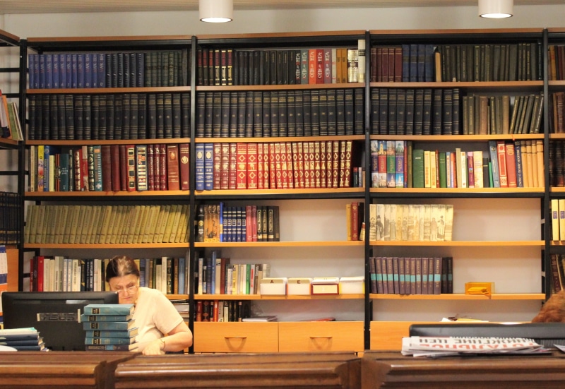 young adult, archive, wearing, large group of objects, library, chair, shirt, indoors, book, newspaper, table, facing, white, development, research, lampshade