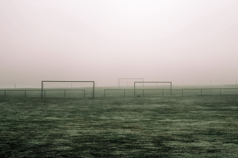 mist, beauty in nature, nature, tranquility, sport, absence, built structure, land, no people, sky, copy space, grass, tranquil scene, minimalism, soccer pitches