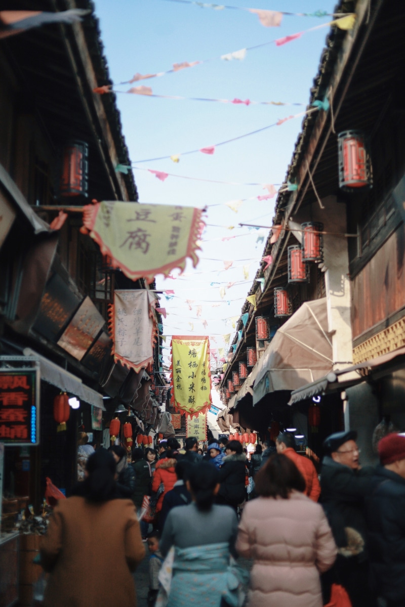person, urban, street market, script, market, architecture, men, shop, daytime, pedestrian, town, hanging, bazaar, gathering, day, building, large group of people