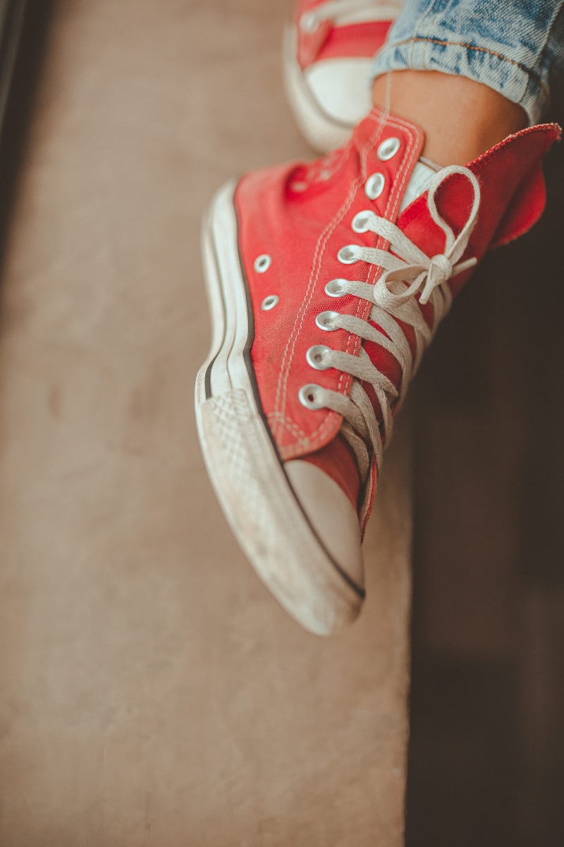 focus on foreground, one person, footwear, human foot, shoelace, wear, fashionable, high, childhood, top, human hand, indoors, flooring, adult, canvas shoe