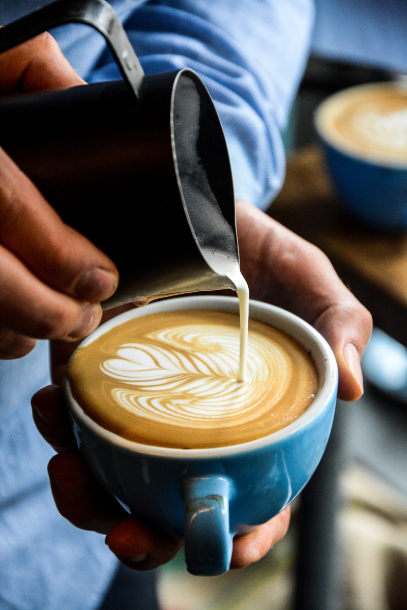 cup, human hand, human body part, barista, milk, hot drink, one person, coffee - drink, froth art, happiness, workshop, pour, mug, passion, coffee lover