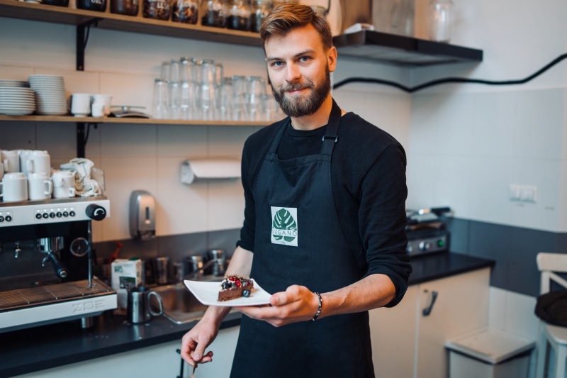kitchen, looking at camera, business, sliced, 5K, electronics, cafe, poland, cake, guy, chef, mid adult, people, dessert, plate, small business, standing