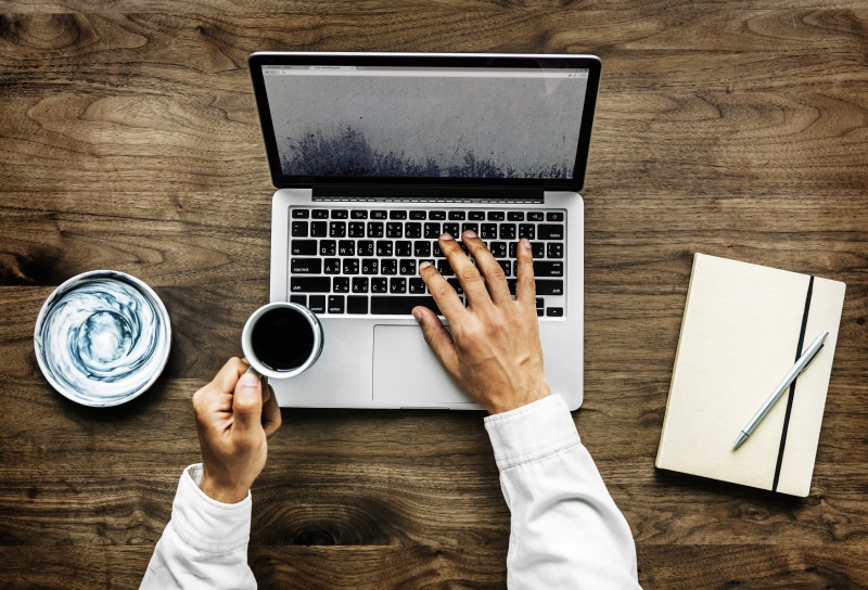 notebook, person, wood - material, laptop, pen, mug, journal, browsing, using laptop, device, using, technology, keyboard, holding, coffee - drink, aerial