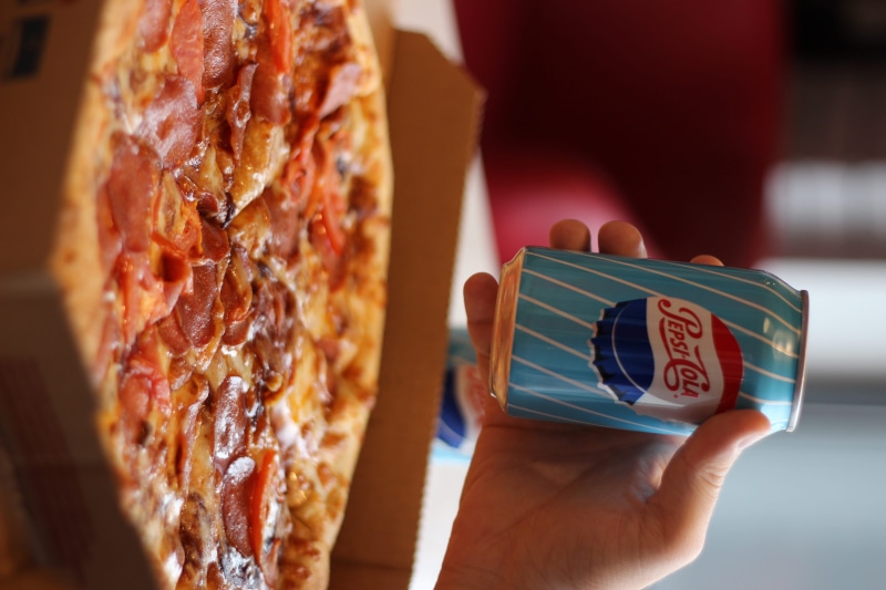 finger, indoors, hand, alcohol, beverage, close-up, can, focus on foreground, processed meat, slice, pepperoni, human, snack, sausage, dominos, one person