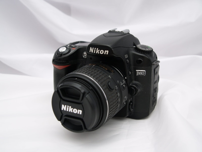 white color, studio Shot, still life, no people, 2K, lens - Optical Instrument, camera, nikon, close-up, number, text, western script, digital camera