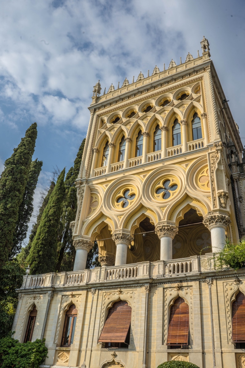 cloud - sky, building, tower, travel, history, the past, arch, lake garda, built structure, building exterior, plant, spire, belief, tree, italy, isola del garda