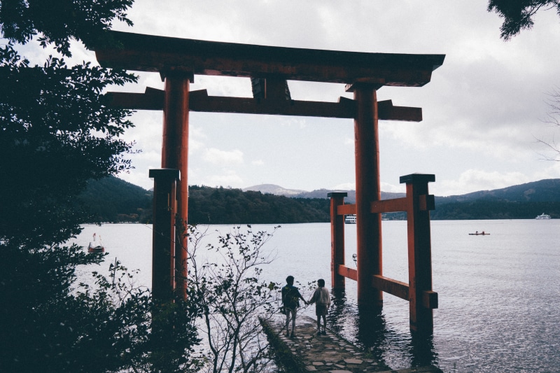 outdoors, human, vehicle, beauty in nature, daytime, asphalt, railing, hakone, plant, religion, red, tranquility, shinto, tranquil scene, torii gate, built structure