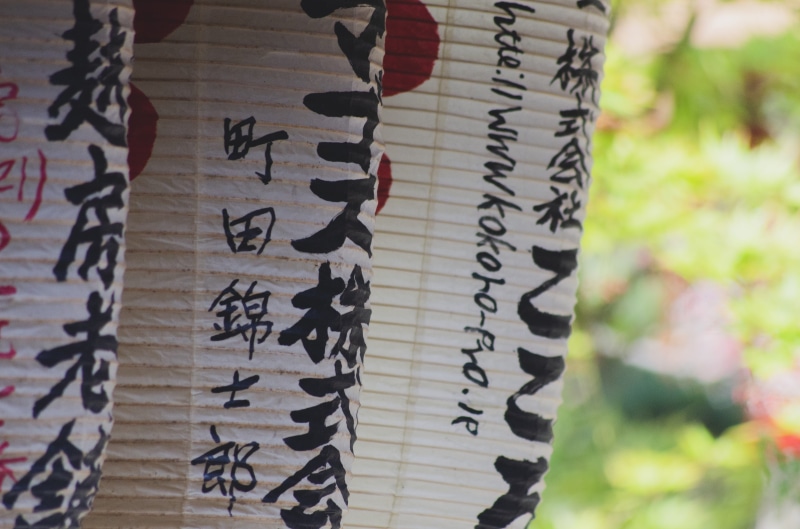 text, bird, belief, script, floral pattern, art and craft, label, beverage, no people, day, sake, handwriting, focus on foreground, sticker, calligraphy