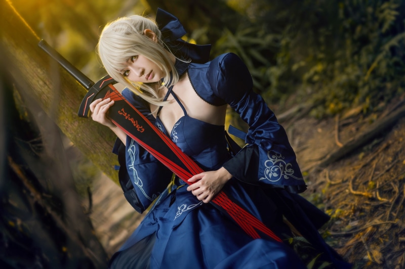 sword, bangs, hairstyle, sitting, bow, girl, blue dress, look, portrait, cosplay, costume, weapons, Asian, blue, hands, image, blonde, forest, 1080P, nature