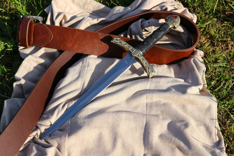 field, human leg, human limb, outdoors, weapon, day, 5K, men, shadow, high angle view, midsection, nature, real people, musical instrument, casual clothing