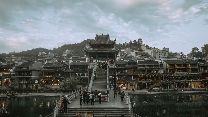 city, incidental people, sky, travel, people, tree, urban, tourism, place of worship, pagoda, mountain, town, nature, water, building exterior, worship