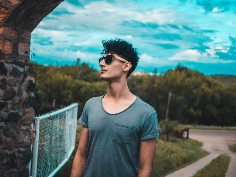 plant, standing, wall, leisure activity, one person, brick, 4K, gate, day, hair, front view, skinny, real people, waist up, sunglasses, beside, cool, tree