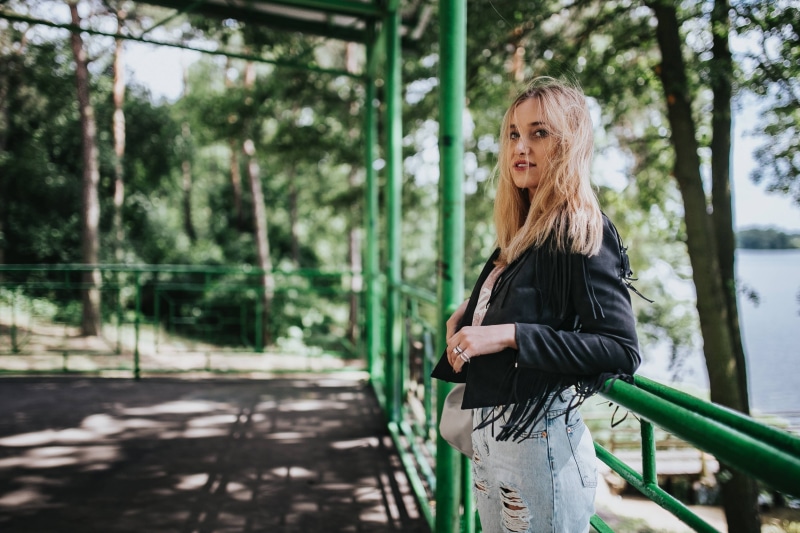 woman, leather, hairstyle, three quarter length, leisure activity, looking at camera, standing, one woman only, contemplation, adults only, tree, black