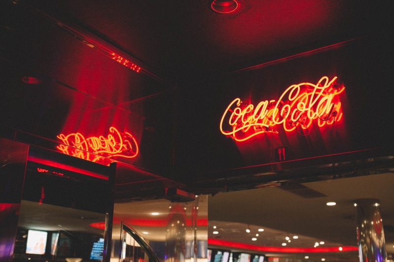 town, commercial sign, meal, logo, signage, cola, transportation, urban, no people, low angle view, city, ampersand, store, lighting, terminal, light, trademark