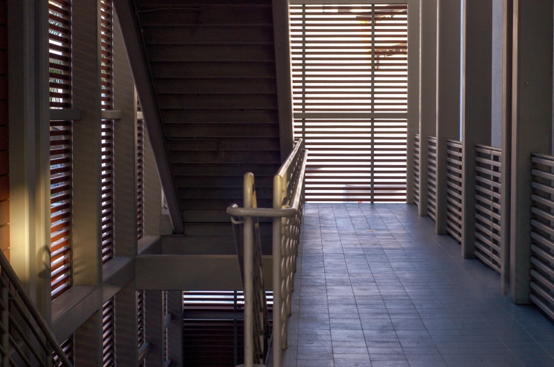 empty, hardwood, no people, floor, architecture, chair, lobby, pattern, built structure, window, ceiling, curtain, order, shutter, seat, banister, staircase