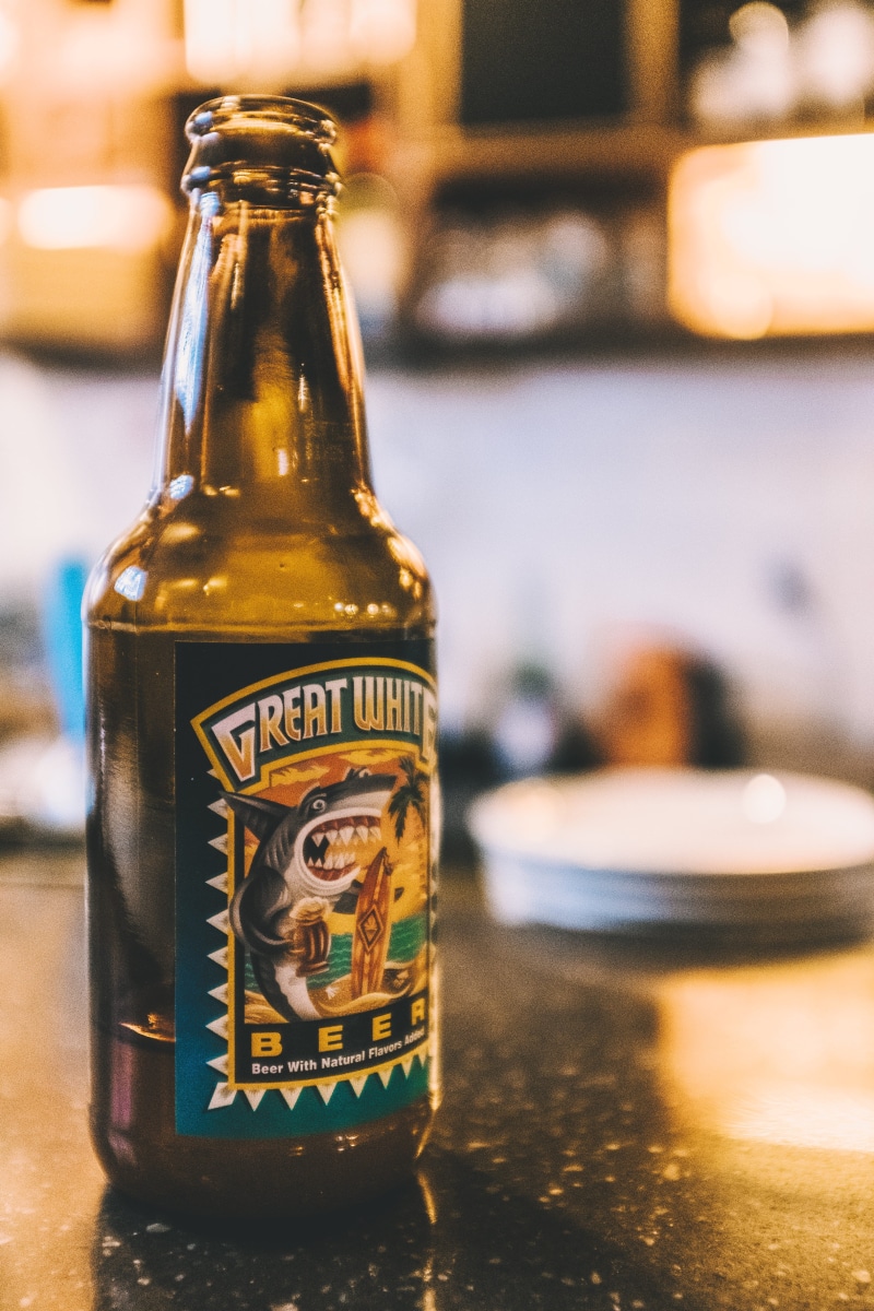 still life, bottle, western script, machine, lager, wheel, alloy wheel, single object, table, stein, bottle cap, focus on foreground, stout, beverage, wine bottle