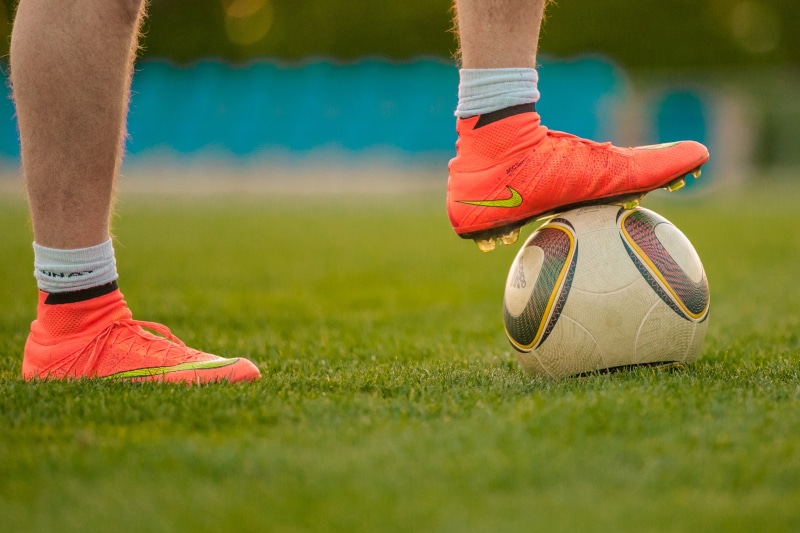 football pitch, cleats, human limb, day, sports ground, football field, penalty area, club, sport, human leg, footballers, orange, sportsman, grass, plant