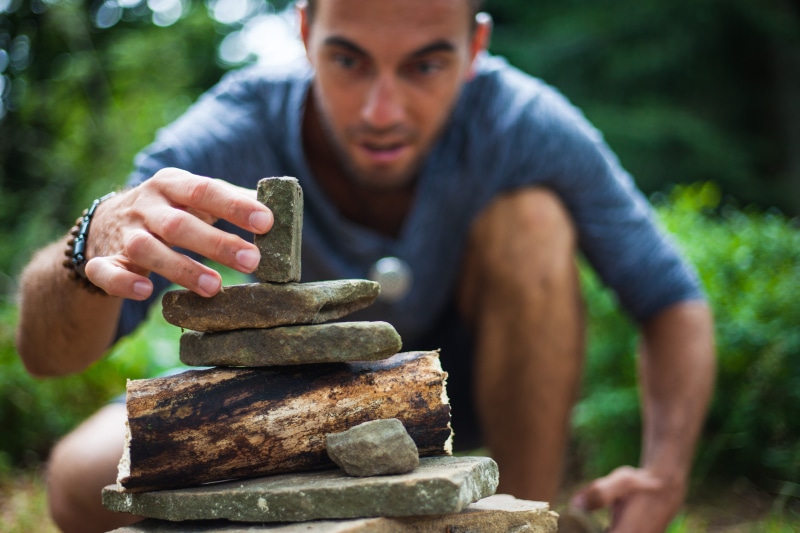 large, solid, stone - object, wood, nails, effort, smile, focus on foreground, cube, where, concentration, teeth, bracelet, sleeved, green, front view