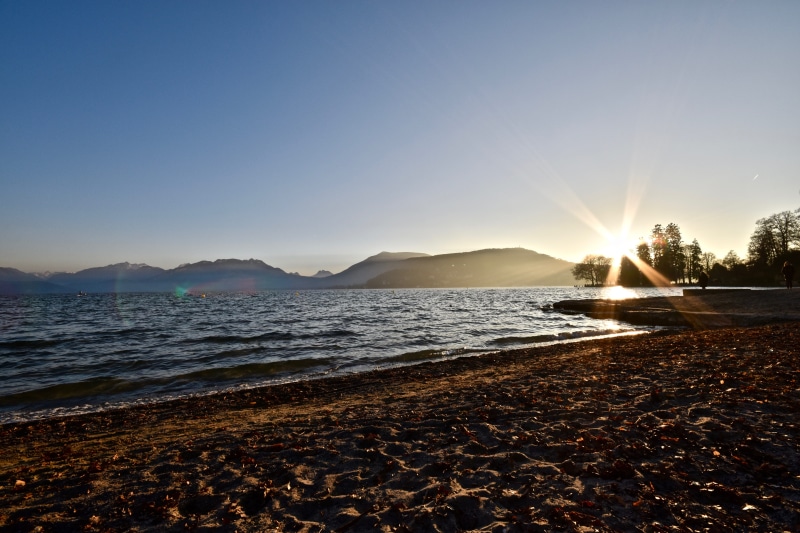 nature, beach, sand, waves, sunbeam, lake, outdoors, sun, annecy, non-urban scene, sea, 5K, sky, france, clear sky, mountains, sunset, sunlight, day, tranquil scene