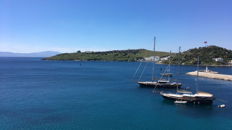transportation, sky, waterfront, beauty in nature, anchored, moored, water, sailboat, tranquility, sea, mountain, port, yacht, outdoors, clear sky, nature
