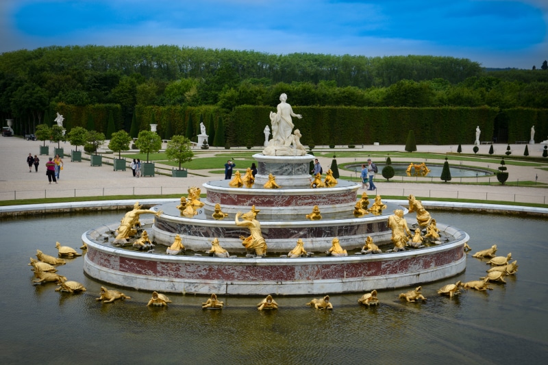 sculpture, travel, human representation, tourism, architecture, creativity, male likeness, nature, versailles, tree, day, plant, water, cloud - sky, religion