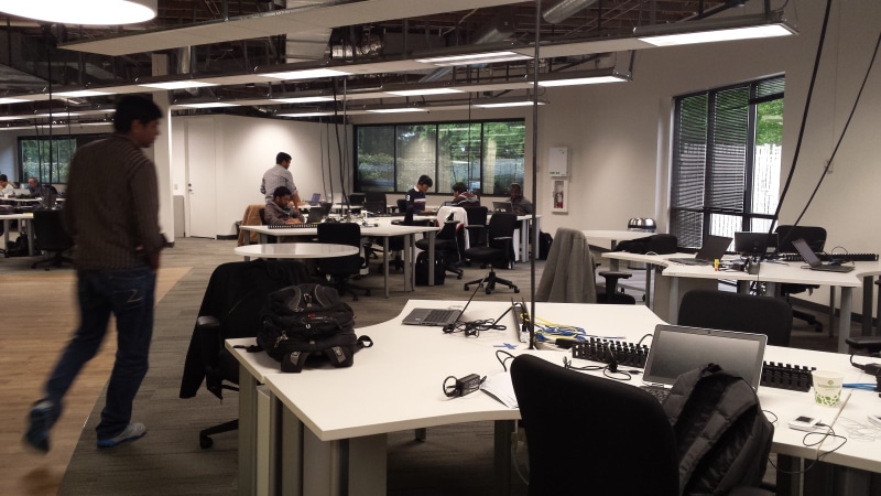person, computer, rug, gray, jeans, long, area, beige, design professional, indoors, denim, group of people, cooperation, table, working, human, walking