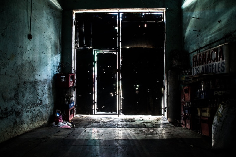 dark, indoors, lifestyles, architecture, flooring, building exterior, closed, storage, building, entrance, outdoors, real people, one person, door, wall - building feature