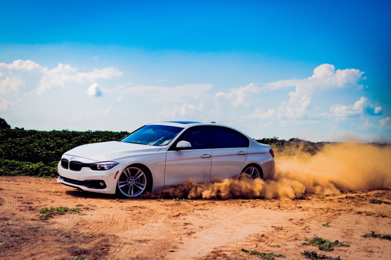 transportation, day, outdoors, travel, field, smoke - physical structure, road, motion, motor vehicle, no people, sky, environment, dust, cloud - sky, mode of transportation