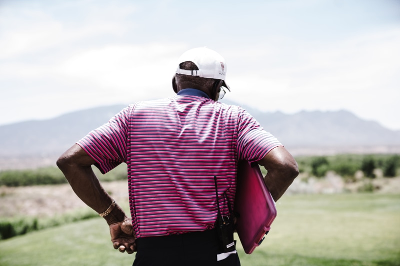 golf course, sky, case, men, nature, person, adult, focus on foreground, one person, day, daytime, clipboard, mountain, landscape, grass, caddie, standing