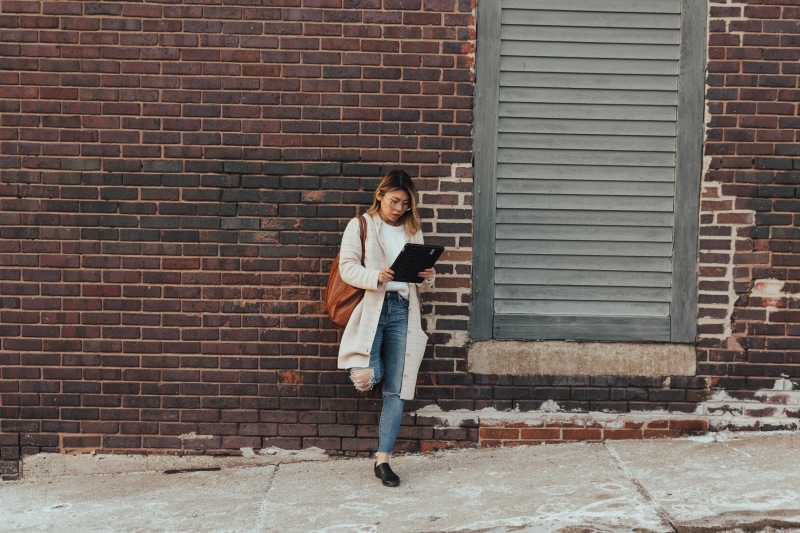 holding, black, hairstyle, lifestyles, brick wall, outdoors, wall - building feature, portrait, building exterior, standing, adult, casual clothing, young adult