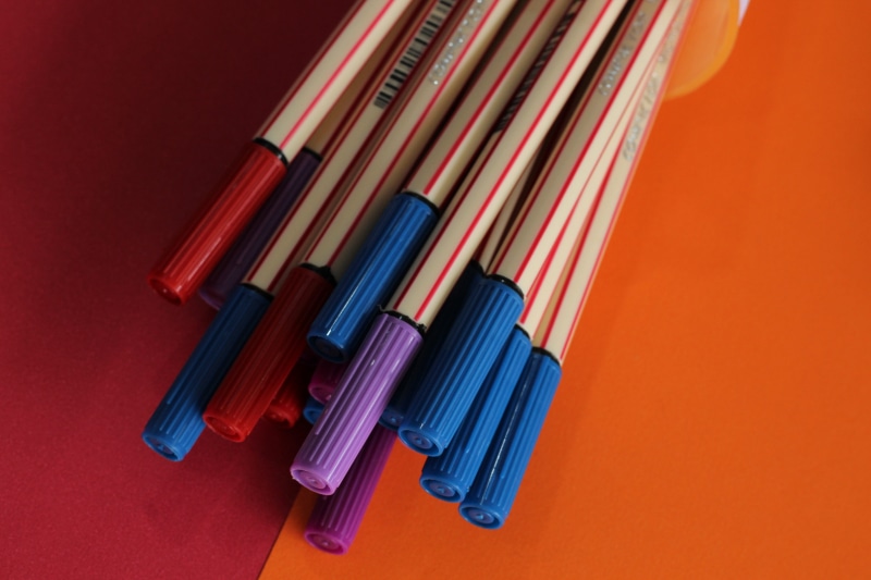 school supplies, craft, multi colored, orange background, pen, studio shot, school, 5K, still life, head, orange color, paper, wire, indoors, orange, colored background