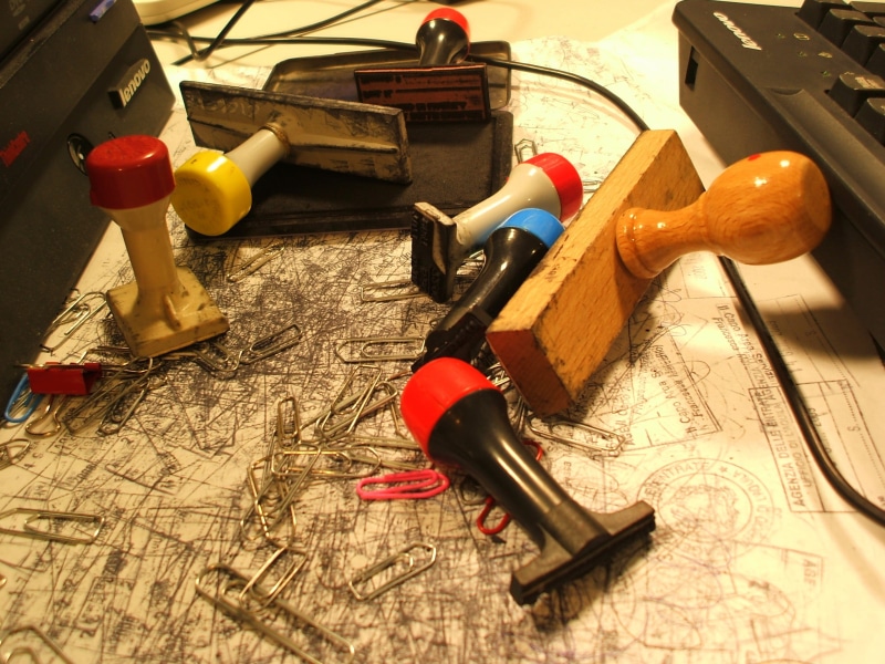 large group of objects, indoors, table, no people, variation, map, high angle view, clutter, stamp, close-up, office, equipment, still life, wooden, writing instrument